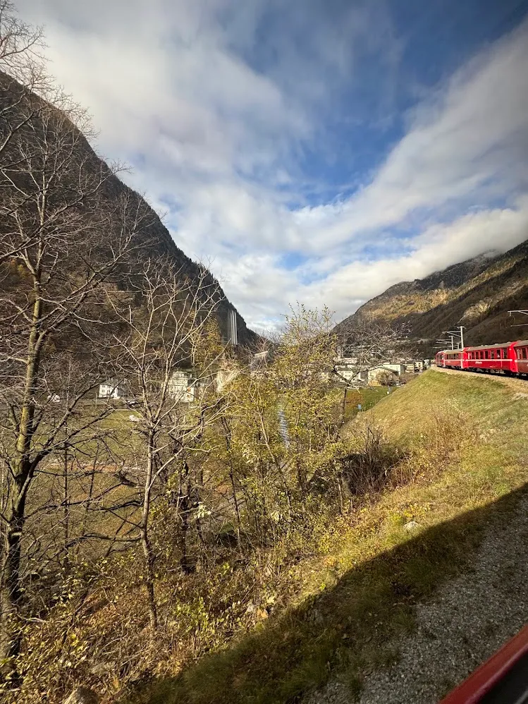Un tren rojo recorriendo un valle alpino en la ruta del Bernina