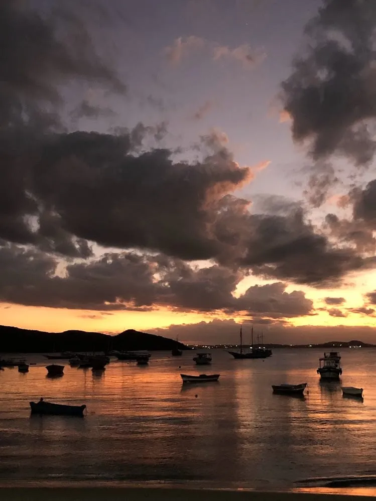 Botes en silueta al atardecer en una bahía cerca de Búzios