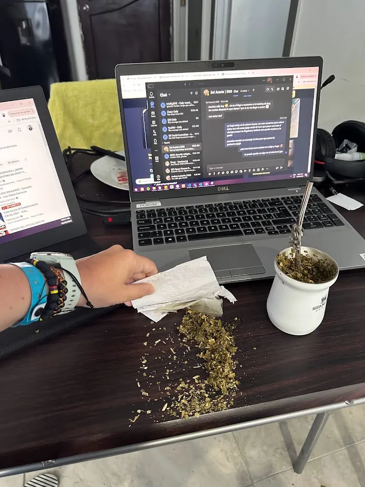 Un escritorio de trabajo remoto con notebooks y mate derramado en Cartagena
