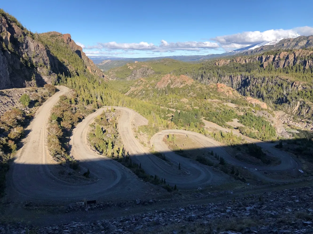 Un camino de ripio serpenteante entre montañas boscosas de la Patagonia en Chubut