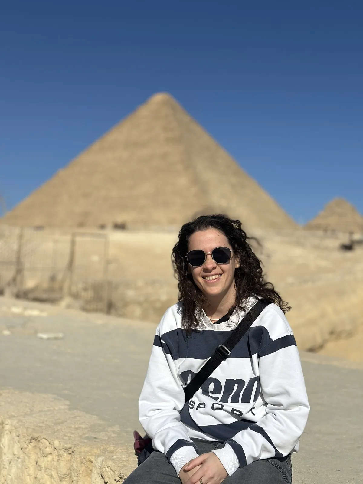 Una viajera sentada frente a la Gran Pirámide de Guiza