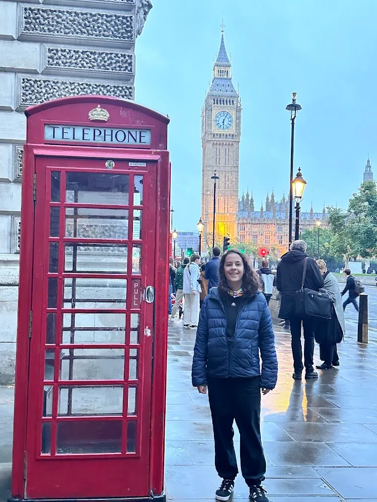Una cabina telefónica roja y la Torre de Isabel en una tarde lluviosa de Londres