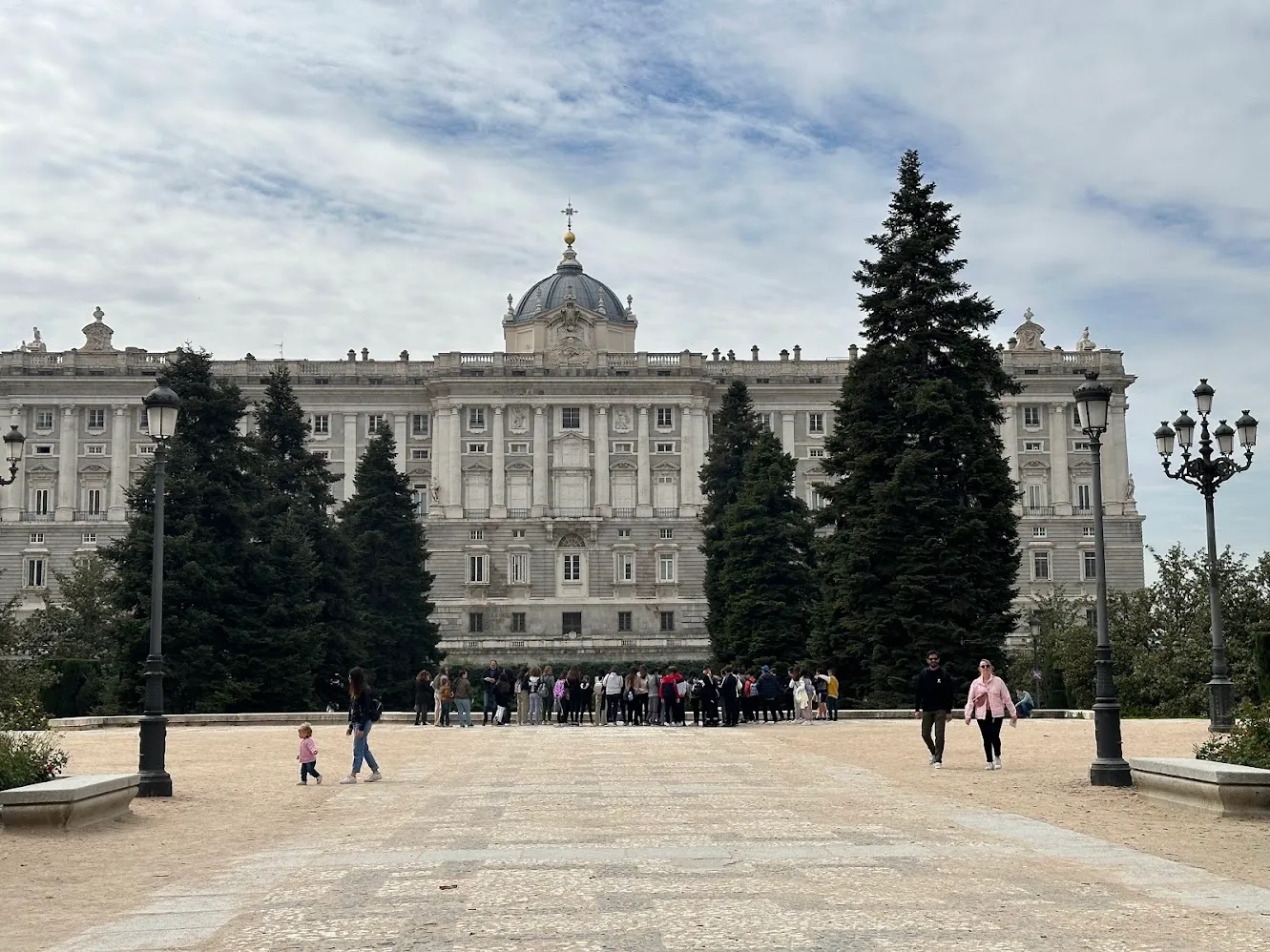 El Palacio Real de Madrid desde la plaza de piedra bajo un cielo nublado
