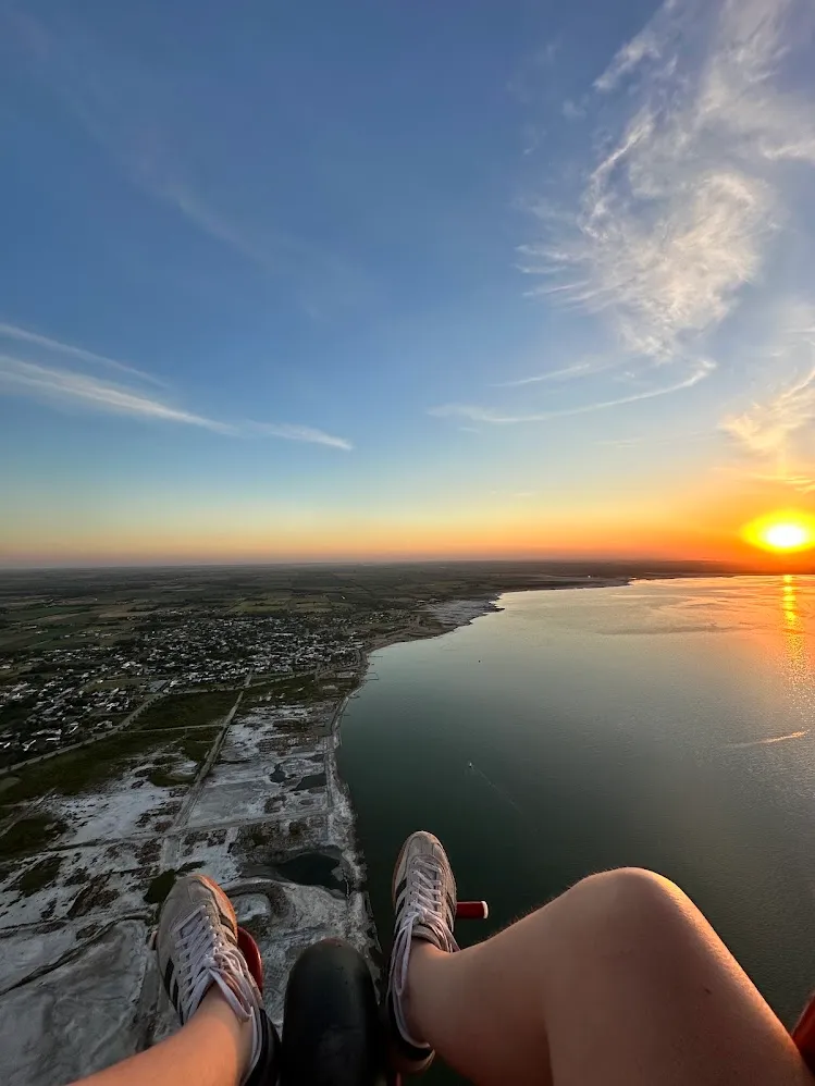La vista desde un parapente de un lago iluminado al atardecer