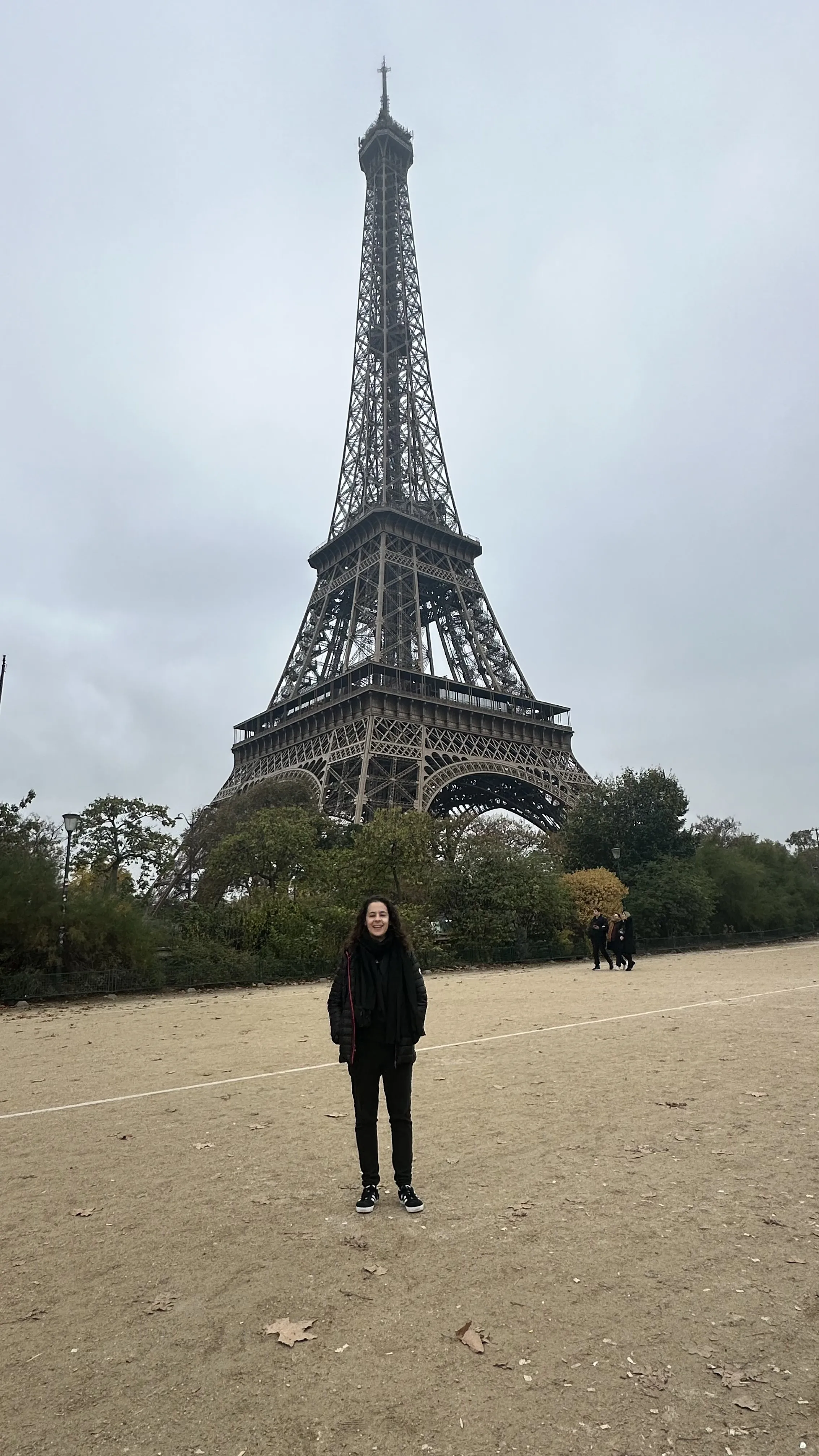 Una viajera frente a la Torre Eiffel en un día nublado