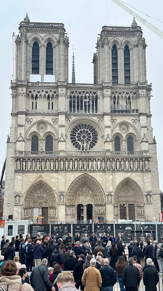 La fachada oeste de Notre-Dame con andamios y una multitud durante la restauración