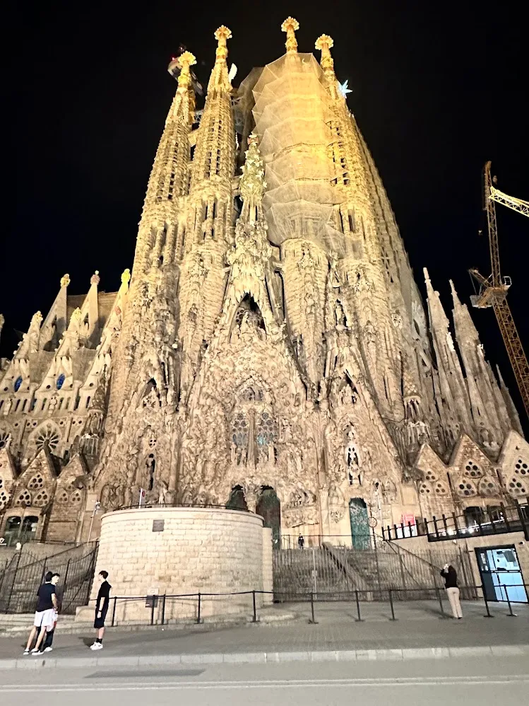 La Sagrada Familia iluminada elevándose en el cielo nocturno de Barcelona