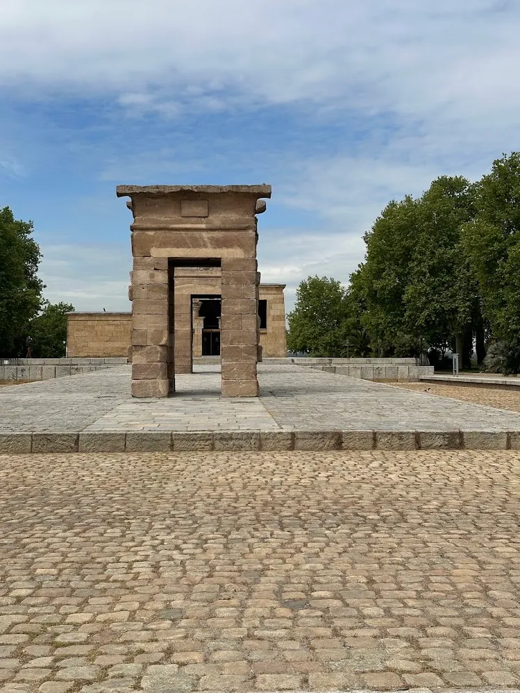 Los pilonos de piedra del Templo de Debod alineados bajo un cielo azul