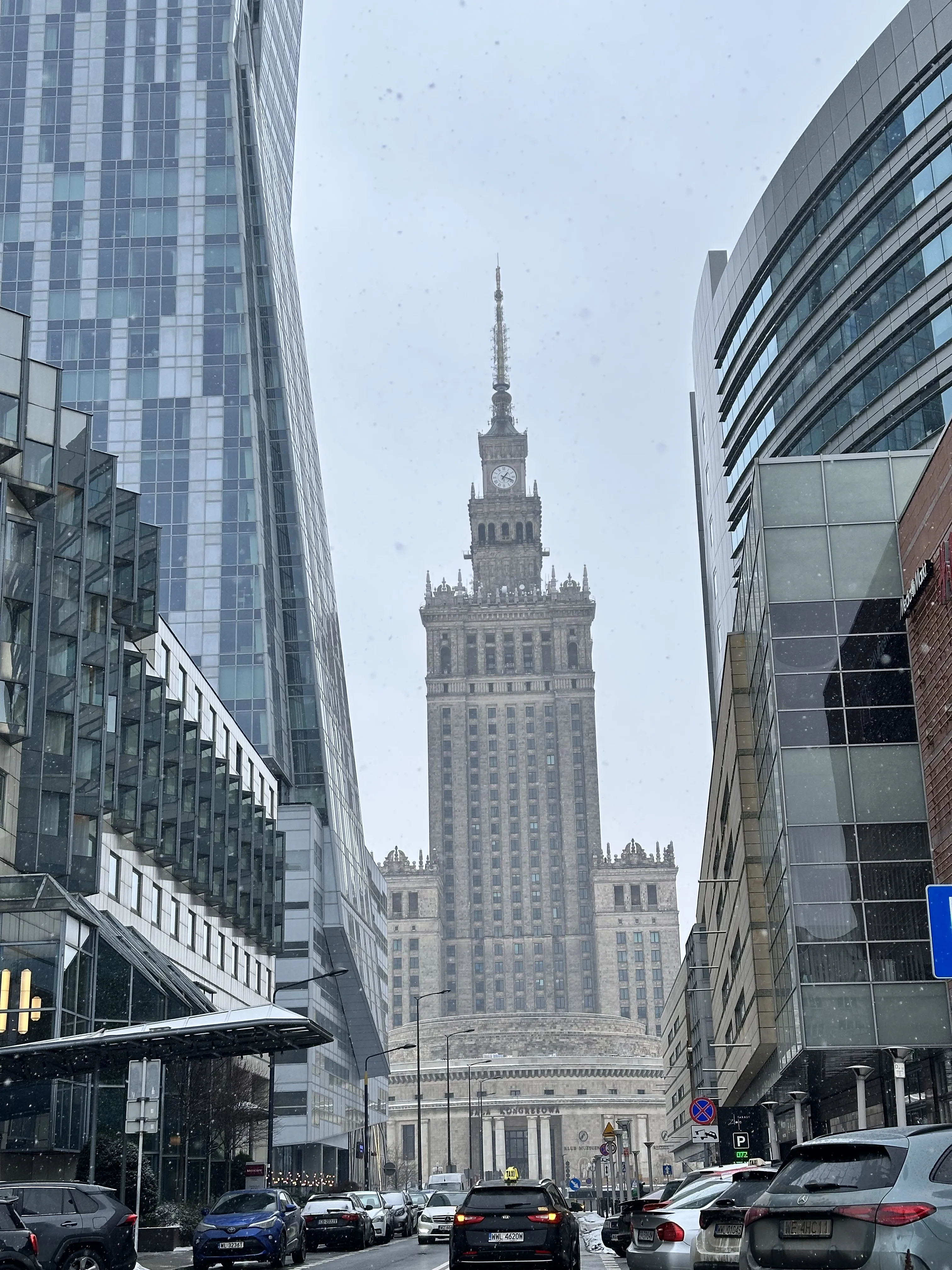 El Palacio de la Cultura y la Ciencia enmarcado por torres modernas de cristal en un día nevado